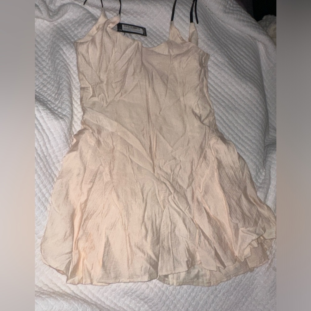 Adorable Cream Colored Mini Dress with a flowy bottom and buckle straps!